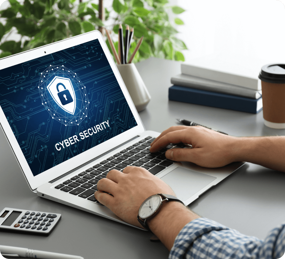 Person working on laptop, cybersecurity screen displayed.